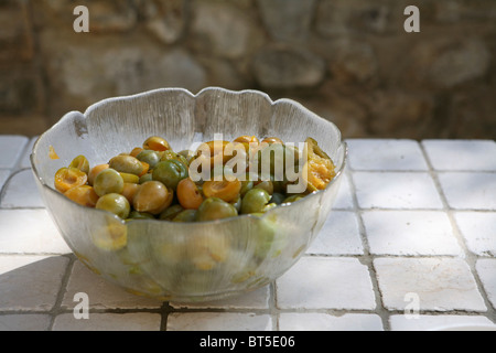 (Prunus x domestica var. syriaca) Halved and stoned Mirabelle plums in a glass bowl. Stock Photo