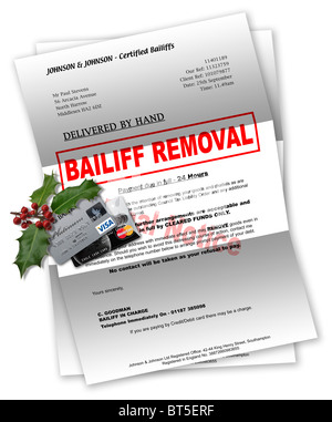 Bailiff letter with credit cards and Christmas holly on top Stock Photo