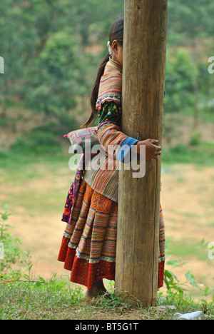 Shy 'Flower Hmong' girl in traditional attire near Sapa, Vietnam Stock Photo