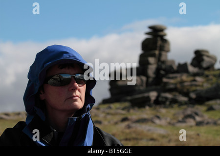 Female walker in blue walking gear on Dartmoor, with Staple Tor in the background. Stock Photo