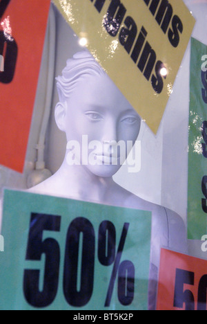 Female white mannequin head in window of shop with sale signs Stock Photo