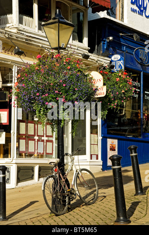 Bike leaning on lamp post outside Row of shops stores in town centre Montpellier Parade Harrogate North Yorkshire England UK United Kingdom Stock Photo