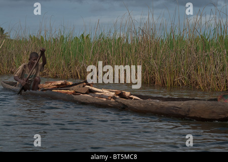 Man transporting wood along Canal des Pangalanes, Madagascar. Stock Photo