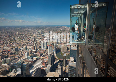 Tourists in glass balcony skydeck observation deck view Chicago skyline103rd floor of the Willis Tower Sears Tower Stock Photo