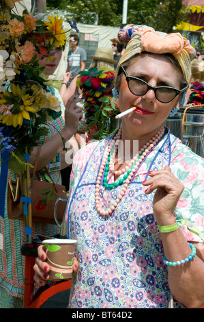 2010 Glastonbury Festival of Contemporary Performing Arts festival Tea lady fag cigarette bead beads scarf head woman female red Stock Photo