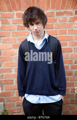 Teenage boy wearing navy blue school uniform shirt hanging out Stock Photo