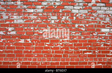 Decayed brick wall covered by a red paint Stock Photo