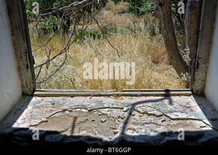 View to nature scene from the window of an abandoned rural house. Stock Photo