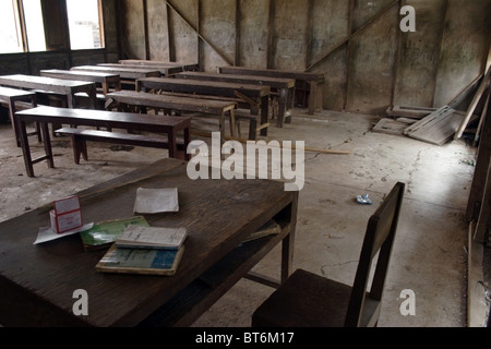 Old broken wooden tables and benches in poor condition serve students and teachers at a primary school in communist Laos. Stock Photo