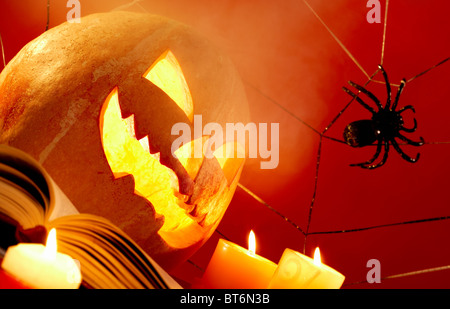 Image of Halloween pumpkin with burning candles and cobweb with spider near by Stock Photo