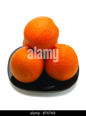 Oranges on a black plate on a white background