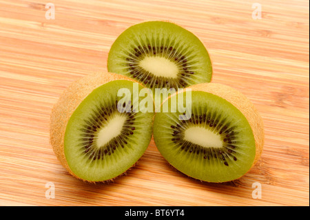 Kiwi (Actinidia deliciosa), cut in half on a wooden board Stock Photo