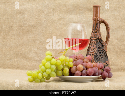 Bright still life with grapes and wine on sacking background Stock Photo