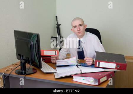 The chief in a white shirt on a workplace with a rifle on a background Stock Photo