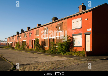 A row of derelict terraced housing awaiting demolition in the Clayton district of Manchester, England, UK Stock Photo