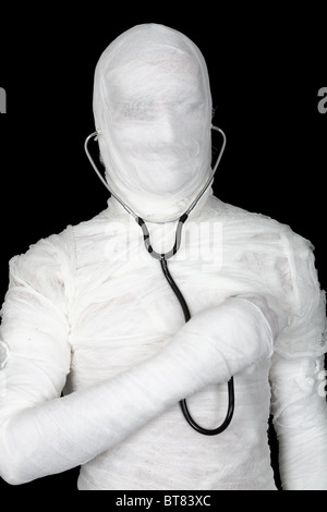 Man in costume mummy with stethoscope on black Stock Photo