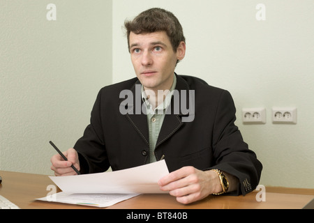The clerk at office sits at a desktop Stock Photo