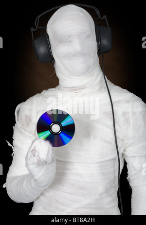 Man in bandage with ear-phones and disc on black Stock Photo