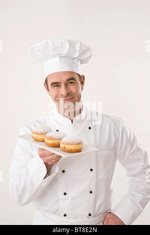 Confectioner presenting pastries on a porcelain plate Stock Photo