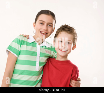 Potrait of a smiling boy and a smiling girl, holding each other arm in arm Stock Photo