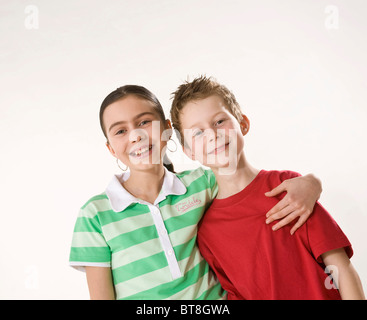 Potrait of a smiling boy and a smiling girl, holding each other arm in arm Stock Photo
