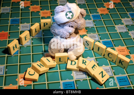 Childs teddy bear with scrabble letters, help sick children. Stock Photo