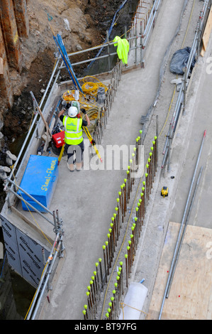 Yellow safety caps on projecting steel bars & steel fixers ...