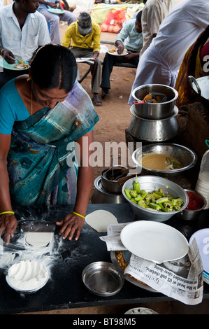 Indian women making puri in a shop on the street in India Stock Photo