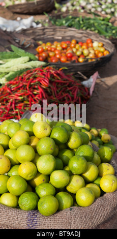 Sack of lemons, basket of red chillis in an India market Stock Photo