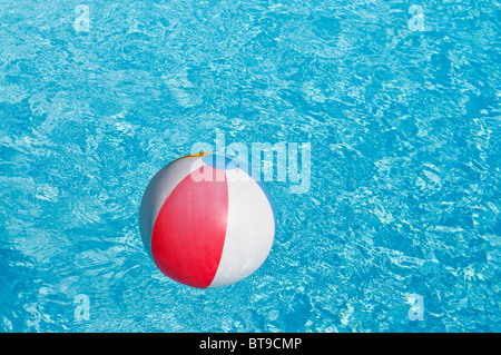 A beach ball floating in a swimming pool Stock Photo