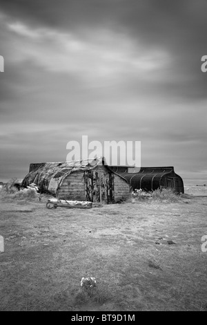 Upturned herring boats used for storage by local fishermen, Lindisfarne, Northumberland Stock Photo