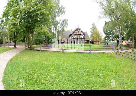 Replica of early 20th century hut with arcade extension, partly half-timbered wall and thatched roof from Masuria region, Poland Stock Photo