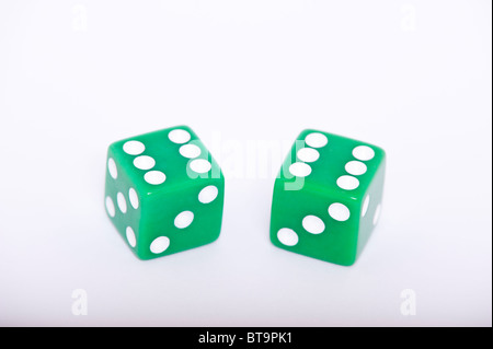 A pair of green dice both showing a six on a white background Stock Photo