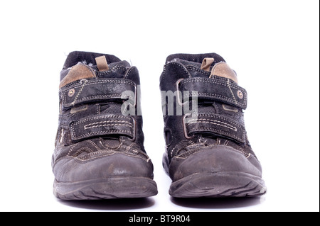 A pair of well worn boys boots on a white background Stock Photo