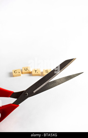A pair of scissors and the word 'Cuts' in scrabble tiles Stock Photo
