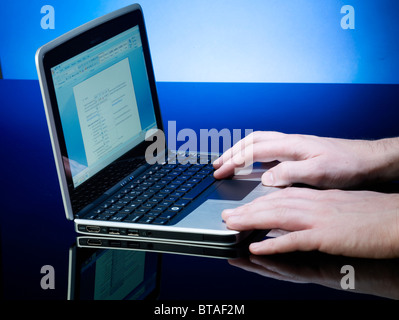 Hands typing on a small netbook laptop Stock Photo