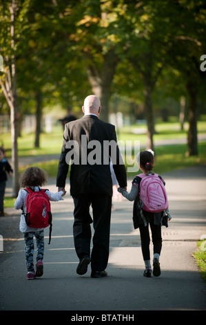 Rear view of father and children walking hand in hand Stock Photo - Alamy