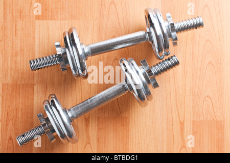 chrome dumbells on wooden floor Stock Photo