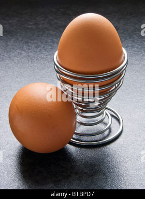Eggs in modern spiral metal egg cup on bench top Stock Photo