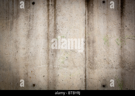 Tall concrete wall in rough, gunge style with stains and wear Stock Photo