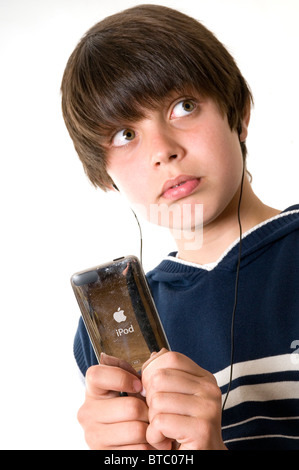 young boy listening to music on an ipod iphone mp3 player headphones headphone downloaded music down load downloads download fil Stock Photo