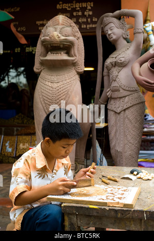 Stone statue of a young boy holding a bird bath in a country