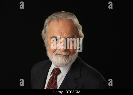 Portrait of bearded and grey haired senior businessman in suit and tie, studio shot, black background, October 16, 2010 Stock Photo