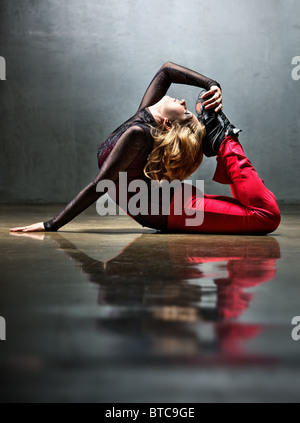 Sits on yoga mat. Woman with sportive slim body type in underwear that is  in the studio 15303407 Stock Photo at Vecteezy