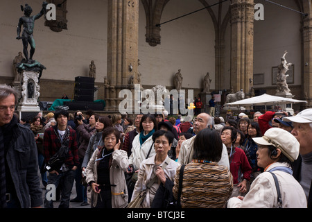 An Asian tour group admires renaissance statues in Florence's Loggia dei Lanzi, Piazza della Signoria. Stock Photo