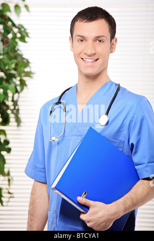 Smiling healthcare professional holding a folder of patient or medical information Stock Photo