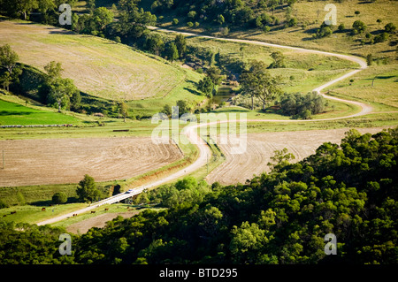 A country road winds its way through fields and meadows Stock Photo