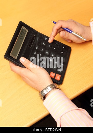 businessman counts money on calculator - close-up view Stock Photo