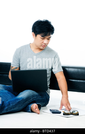 Handsome young man working and sitting on floor with laptop Stock Photo