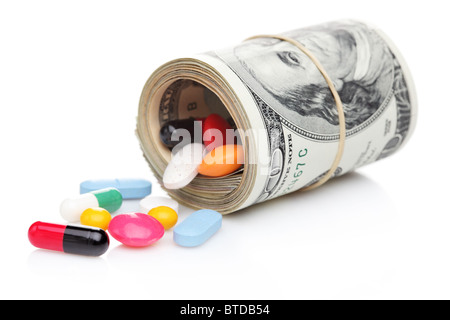 Money rolled up with pills flowing out isolated on white background Stock Photo